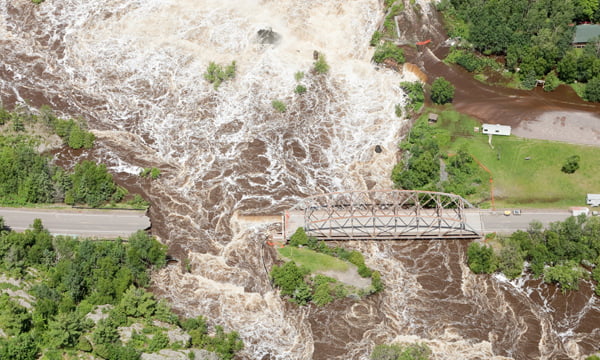 Image of flooded river and broken bridge