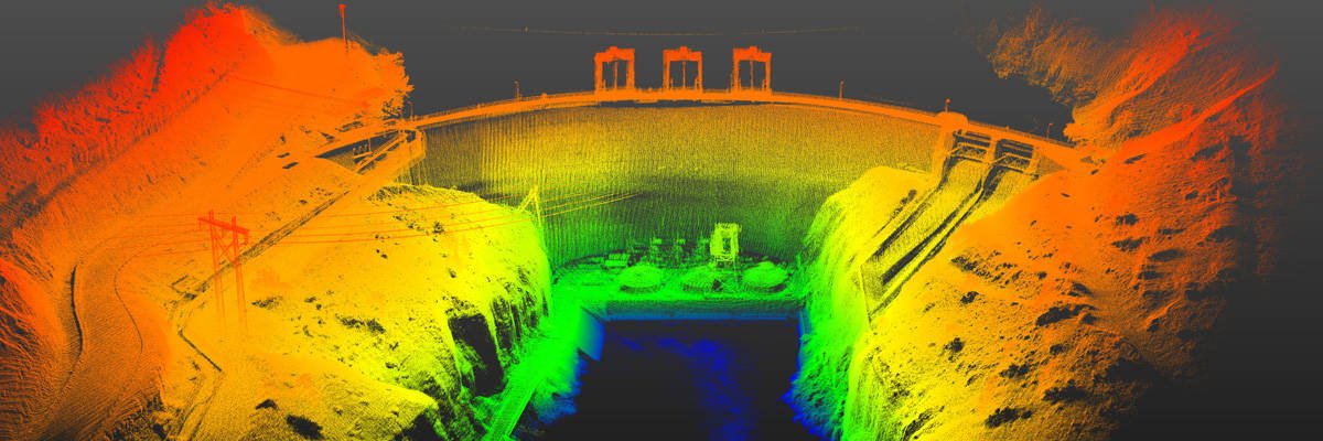 Bright orange, yellow and green point cloud showing the detail of a dam structure in USA including powerlines, water outlets.